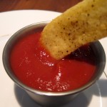 Seasoned French Fry being dipped in Homemade Ketchup