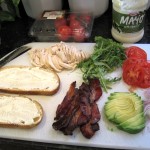 ingredients for a super club sandwich on a cutting board