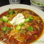 Homemade Chili topped with Cheese, Scallions and Sour Cream