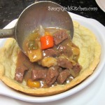 Pouring beef stew into a baked pie crust